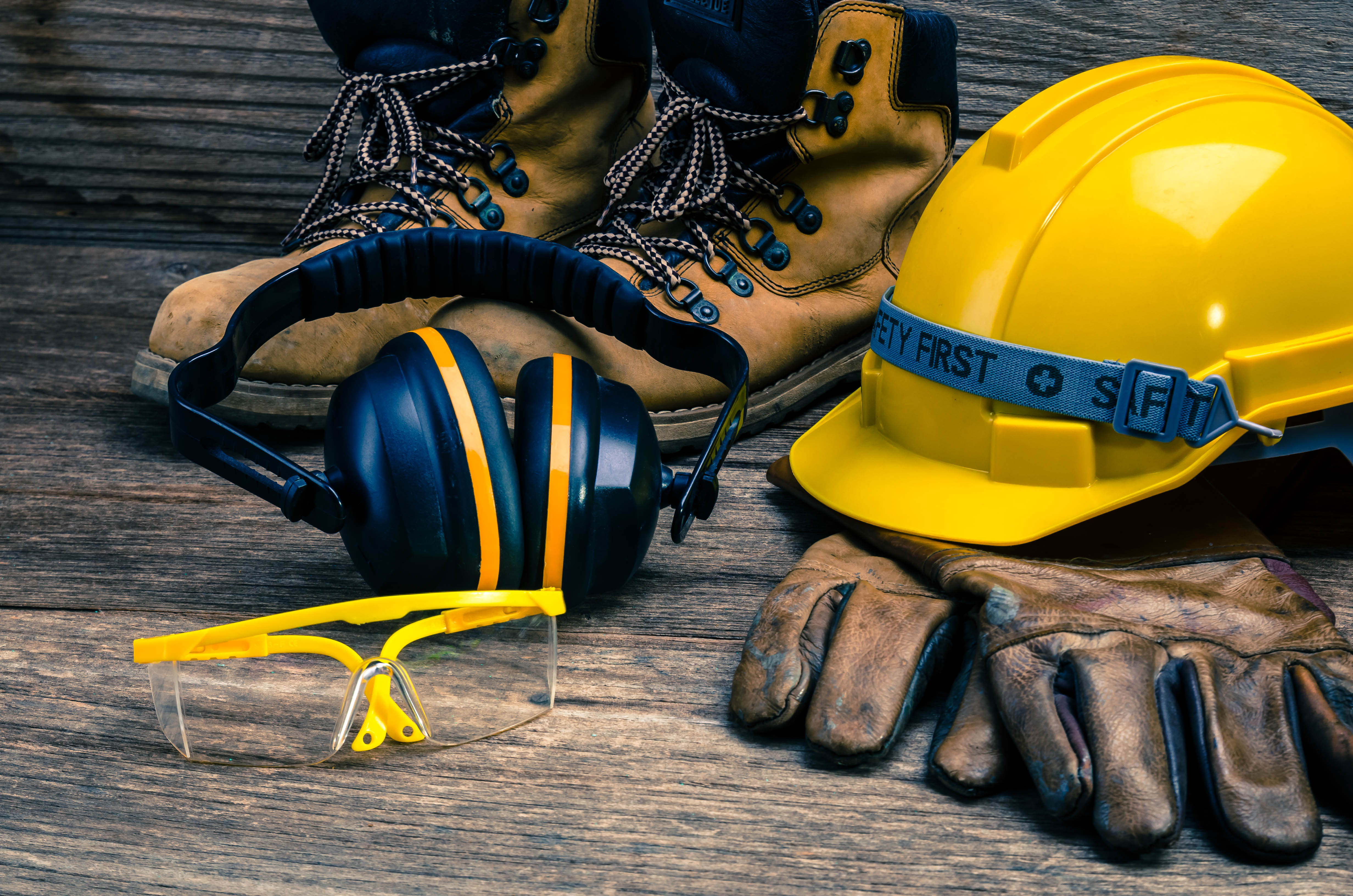 Bauarbeiterhelm, Handschuhe und Schuhe liegen am Boden