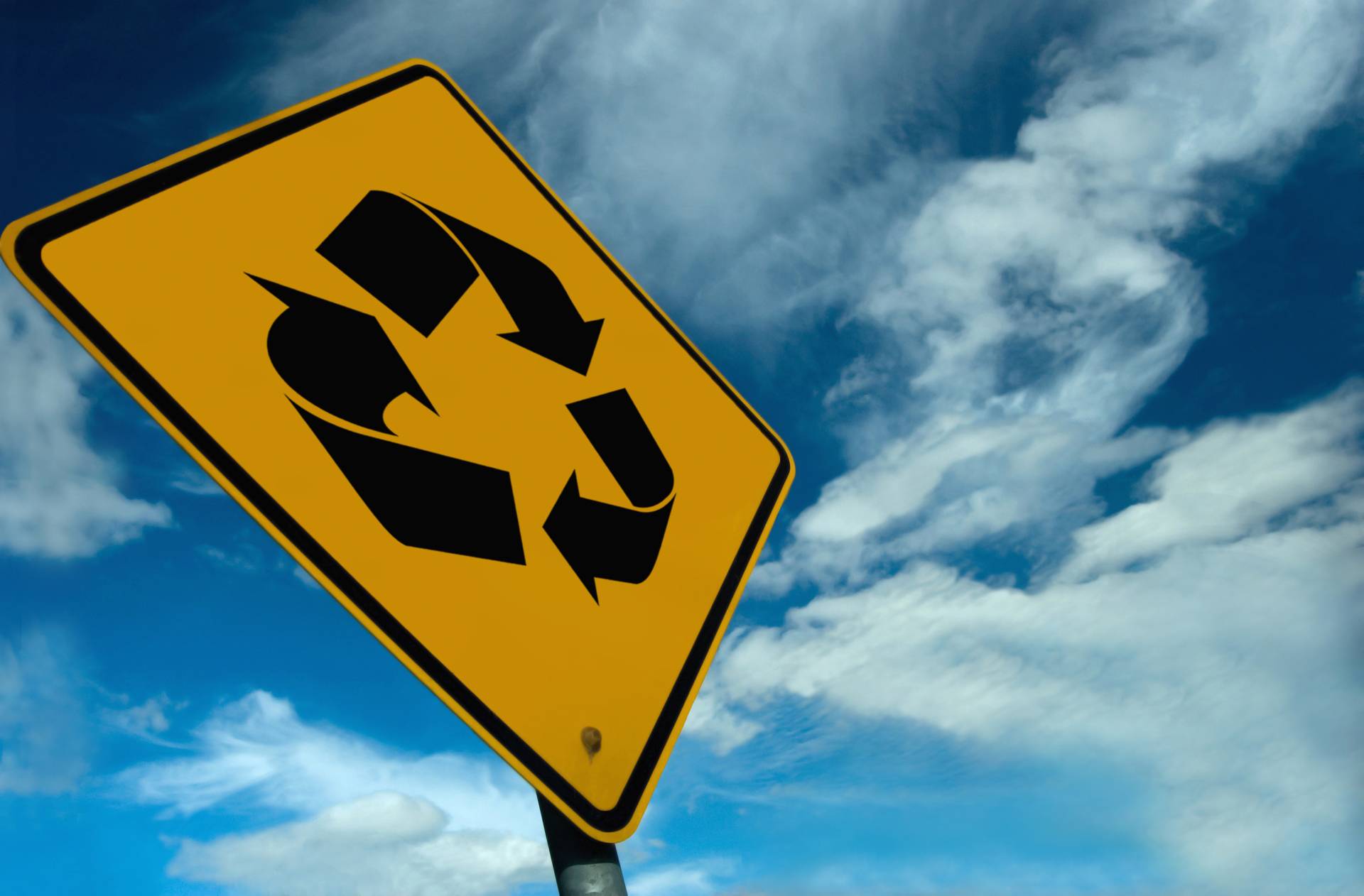 Gelbes Straßenschild mit Recycling-Symbol